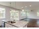 Open kitchen featuring granite counters, a sink island, and pendant lights, flowing into a bright living space at 456 Barbour Farm Ln, Four Oaks, NC 27524