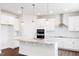 Bright, open kitchen with white cabinets, granite countertops, stainless steel appliances, and a large center island at 456 Barbour Farm Ln, Four Oaks, NC 27524
