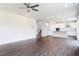 Expansive living room with hardwood floors, ceiling fan, and open layout, next to staircase and kitchen at 456 Barbour Farm Ln, Four Oaks, NC 27524