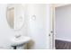 Clean powder room featuring pedestal sink, oval mirror, and natural light at 456 Barbour Farm Ln, Four Oaks, NC 27524