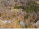 An aerial view showcasing the property and surrounding homes amidst a wooded landscape at 4664 Quarter Creek Ln, Liberty, NC 27298