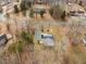 An aerial view of the property and surrounding neighborhood, nestled amongst mature trees at 4664 Quarter Creek Ln, Liberty, NC 27298