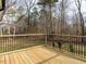 A wooden deck with a metal railing that overlooks the trees in the backyard at 4664 Quarter Creek Ln, Liberty, NC 27298