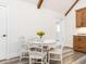 Charming dining area with a white table, wood beams, and modern flooring at 4664 Quarter Creek Ln, Liberty, NC 27298