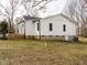 Exterior view of the house with a deck, a well-maintained yard, and a brick foundation at 4664 Quarter Creek Ln, Liberty, NC 27298