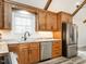 Well-lit kitchen with stainless steel appliances, wood cabinets, and a granite countertop at 4664 Quarter Creek Ln, Liberty, NC 27298