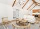 Open-concept living space with exposed beams, hardwood floors, and modern chandelier, flows into the kitchen at 4664 Quarter Creek Ln, Liberty, NC 27298