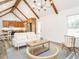 Open-concept living area with kitchen in the background, featuring vaulted ceilings, and modern furniture at 4664 Quarter Creek Ln, Liberty, NC 27298