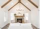 Bright living room with stone fireplace, vaulted ceilings, exposed beams, and stylish chandelier at 4664 Quarter Creek Ln, Liberty, NC 27298