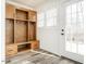 Organized mudroom featuring custom wooden lockers, storage drawers, and a light-filled entryway at 4664 Quarter Creek Ln, Liberty, NC 27298
