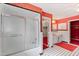 Retro bathroom featuring a classic shower-tub combo, colorful red wallpaper, and vintage tile flooring at 4701 Morehead Dr, Raleigh, NC 27612