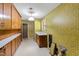 Functional laundry room with retro wallpaper, cabinets, and utility connections at 4701 Morehead Dr, Raleigh, NC 27612