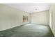 Spacious living room with large windows bringing in natural light and worn, green carpeting at 4701 Morehead Dr, Raleigh, NC 27612