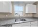 Stylish kitchen with a stainless steel sink, granite countertops, and white cabinets at 4806 Flat Bastion Dr, Raleigh, NC 27610