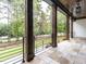 Covered patio with stone tile flooring, wooden columns, and views of a large manicured yard and lush landscaping at 49 Clear Springs Ct, Pittsboro, NC 27312