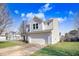 Side view of a two-story home with a two-car garage, green lawn, and gray siding on a sunny day at 5416 Kissimmee Ln, Raleigh, NC 27616