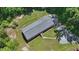 An aerial view of a single-story home featuring a wooden walkway and surrounded by lush greenery at 610 Apple St, Gibsonville, NC 27249