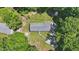 Birds-eye view of home in wooded area, featuring new roof, long driveway, and ample green space at 610 Apple St, Gibsonville, NC 27249