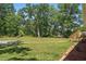 Large grassy backyard features mature trees, offering ample space for outdoor activities and relaxation at 610 Apple St, Gibsonville, NC 27249