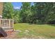 An expansive backyard with a small deck and mature trees for privacy at 610 Apple St, Gibsonville, NC 27249