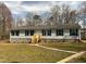 Inviting single-story home with light siding, green shutters, and wooden stairs leading to a white door at 610 Apple St, Gibsonville, NC 27249