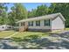 Well-maintained single-story home with teal shutters, complemented by a neatly landscaped yard and gravel driveway at 610 Apple St, Gibsonville, NC 27249