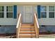 Inviting front entrance with freshly stained wooden steps, trimmed bushes, and house number above the door at 610 Apple St, Gibsonville, NC 27249