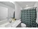 Well-lit bathroom featuring a modern vanity, mirror, and a shower with a decorative curtain at 6318 Perry Creek Rd, Raleigh, NC 27616