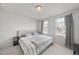 Comfortable bedroom featuring plush carpeting, a tufted headboard, and abundant natural light from two windows at 6318 Perry Creek Rd, Raleigh, NC 27616