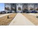 Exterior view of townhomes with garages, driveways, and manicured lawns at 6318 Perry Creek Rd, Raleigh, NC 27616