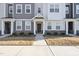 Inviting townhome entrance with stone accents, landscaped bushes, and a covered entryway at 6318 Perry Creek Rd, Raleigh, NC 27616