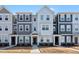 Modern townhome with a mix of white and gray siding, complemented by stone accents on the lower facade at 6318 Perry Creek Rd, Raleigh, NC 27616