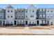 Modern townhome featuring gray and white siding, symmetrical windows and covered front entryways at 6318 Perry Creek Rd, Raleigh, NC 27616