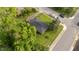 This is an aerial view of a home with dark shingles, a green lawn, and mature trees on a bright, sunny day at 702 Joyner St, Clayton, NC 27520