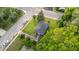This is an aerial view of a quaint home with a dark roof, green grass, and mature trees on a corner lot at 702 Joyner St, Clayton, NC 27520