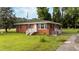 Cozy brick home featuring a well-manicured lawn and charming front entrance with painted white railings at 702 Joyner St, Clayton, NC 27520