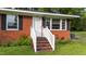 Charming brick home featuring a white front door with a brick step and painted white railing at 702 Joyner St, Clayton, NC 27520