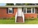 Inviting front entrance with brick steps, a white railing and a bright white front door at 702 Joyner St, Clayton, NC 27520