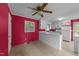 An open kitchen with a ceiling fan and red walls, connecting to other living spaces at 702 Joyner St, Clayton, NC 27520