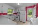 This is a bright, clean kitchen with white cabinets and appliances, with red accents, and a vinyl floor at 702 Joyner St, Clayton, NC 27520
