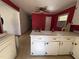 Spacious kitchen with adjacent dining area, featuring white cabinets and a view to a large open area at 702 Joyner St, Clayton, NC 27520