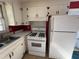 Traditional kitchen with white cabinets and appliances, offering a functional cooking space with vinyl floor at 702 Joyner St, Clayton, NC 27520