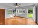 A bright and airy living room featuring hardwood floors, a ceiling fan, and windows overlooking the lawn and street at 702 Joyner St, Clayton, NC 27520