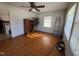 Sunlit living room featuring hardwood floors, a ceiling fan, and natural light from the windows at 702 Joyner St, Clayton, NC 27520