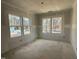 Unfinished bedroom showcasing natural light streaming through three large windows, highlighting the room's potential at 744 Portland Rose Dr, Knightdale, NC 27545