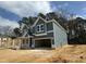 View of the home showcasing its gray siding, architectural details, and the surrounding natural landscape at 744 Portland Rose Dr, Knightdale, NC 27545