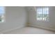 Empty bedroom with neutral walls and carpet with two bright windows overlooking neighborhood at 7723 Roberts Rd, Apex, NC 27523