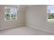 Bright bedroom featuring neutral walls, carpet flooring, and natural light from two well-placed windows at 7723 Roberts Rd, Apex, NC 27523