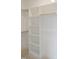 Walk-in closet with white shelving and wooden rods for organization and storage at 7723 Roberts Rd, Apex, NC 27523