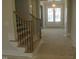 Bright foyer featuring hardwood stairs with black iron spindles and a glimpse of the home's entry doors at 7723 Roberts Rd, Apex, NC 27523